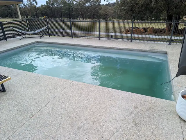 The same pool from the side with cloudy green water